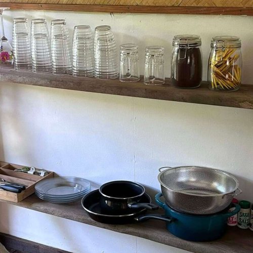 Une étagère avec la vaisselle dans le bungalow Hanamio Hill