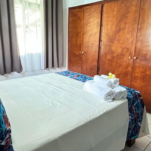 Vue de la chambre parentale de Katu Home prise depuis l’arrière, avec aperçu du lit king size et de la grande armoire.