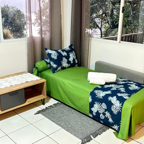 Canapé convertible du salon déplié et préparé pour accueillir un voyageur dans le logement Katu Home à Hiva Oa.