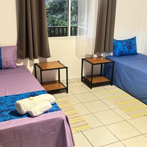 Chambre d’amis de Katu Home avec deux lits simples et une grande armoire, idéale pour enfants ou voyageurs supplémentaires.