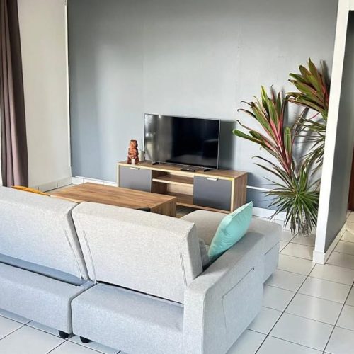 Salon de Katu Home avec vue sur le couloir menant aux chambres et à la salle de bain.