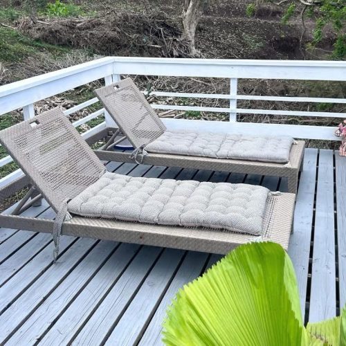 Deux transats sur la terrasse en bois du bungalow Hanamio Bay avec vue extérieure.